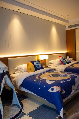 a bedroom with two beds with a hello kitty blanket at Shangrao International Hotel in Shangrao
