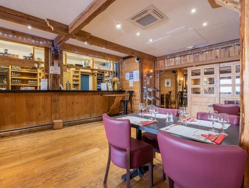 une salle à manger avec une longue table et des chaises violettes dans l'établissement Mont arbois megeve, à Megève