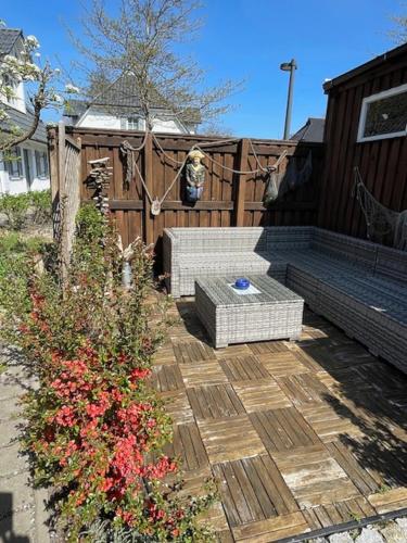 a patio with a bench and flowers and a fence at Ferienhaus Kaptein Meyer in Zingst