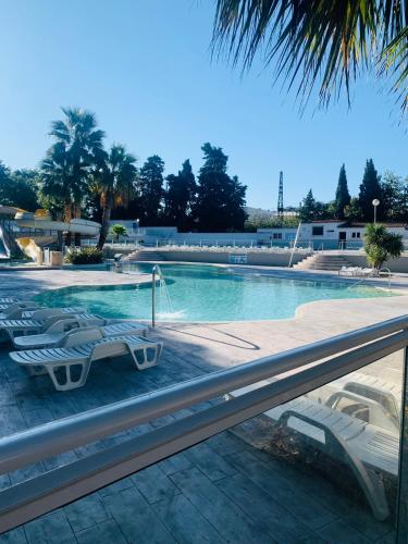 une piscine avec des chaises longues dans un complexe hôtelier dans l'établissement Mobil-home, à Agde