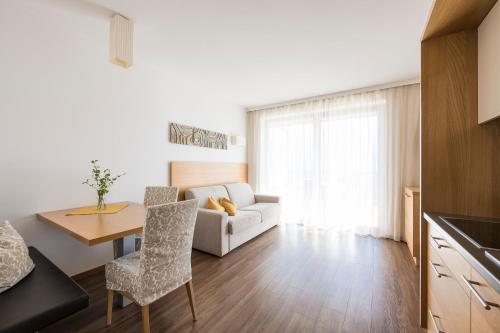 a living room with a white couch and a table at Residence Aqualis in Marlengo
