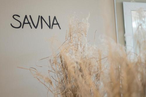 a sign that says samma on a wall with a plant at Residence Aqualis in Marlengo