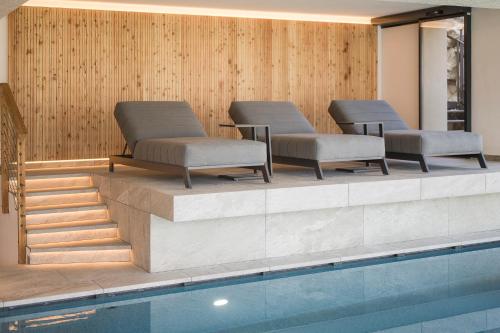 a row of chairs sitting next to a swimming pool at Residence Aqualis in Marlengo