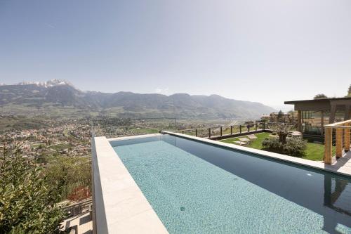 a swimming pool on the side of a house with a mountain at Residence Aqualis in Marlengo