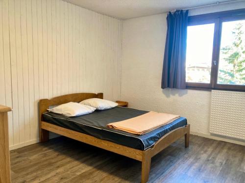 - une chambre avec un lit doté d'un rideau bleu et d'une fenêtre dans l'établissement Résidence Meijotel - 2 pièces Cabine résidence Meijotel MAE-9371, à Vénosc