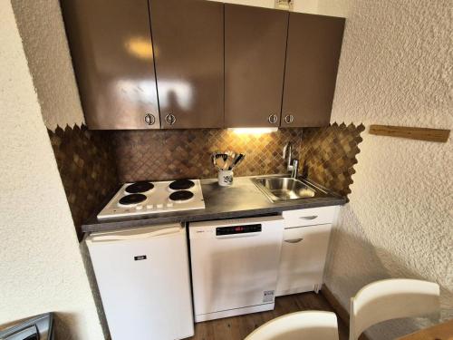 Il comprend une petite cuisine équipée d'une cuisinière et d'un évier. dans l'établissement Résidence Meijotel - Studio résidence Meijotel MAE-9541, à Vénosc