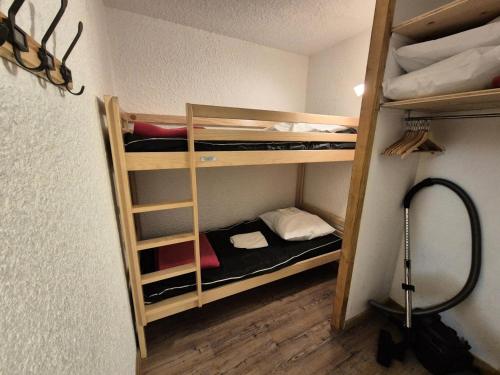 une chambre avec trois lits superposés dans une pièce dans l'établissement Résidence Meijotel - Studio résidence Meijotel MAE-9541, à Vénosc