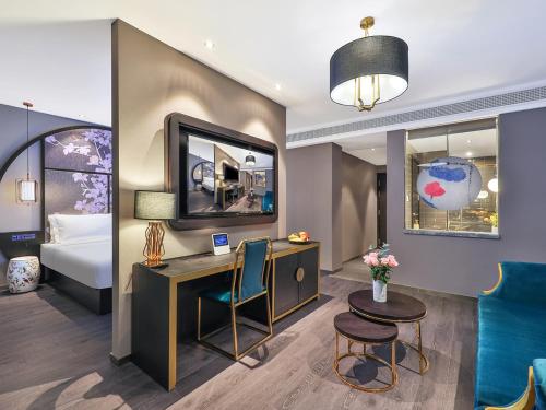 a hotel room with a desk and a bed at 上海五角场桔子水晶酒店 in Shanghai