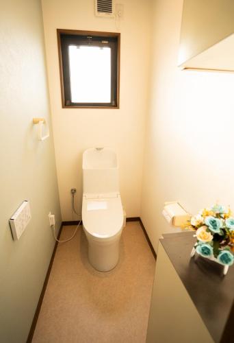 a bathroom with a toilet and a window at raikoエレベーター付き大人数向け一棟貸切宿 in Nishi-biwashima
