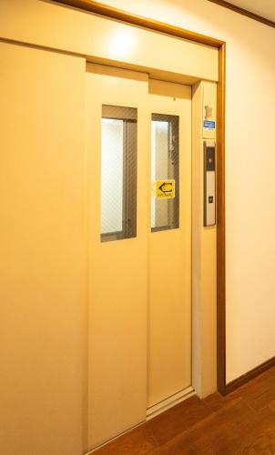 an open door with a sign on it at raikoエレベーター付き大人数向け一棟貸切宿 in Nishi-biwashima