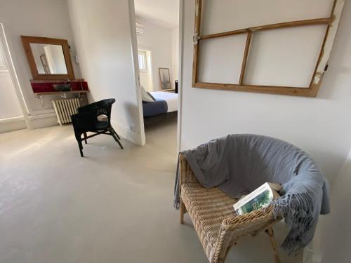 a living room with a chair and a mirror at Le Passagran in Boën