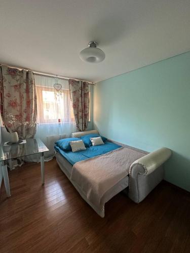 a bedroom with a large bed and a table at Prime Browary Apartment in Warsaw