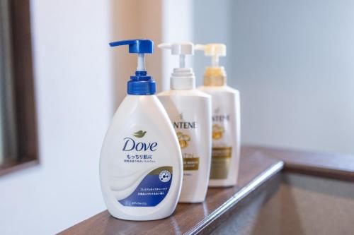 three bottles of cleaning products sitting on a counter at Kstyle Apartments UNO in Tamano