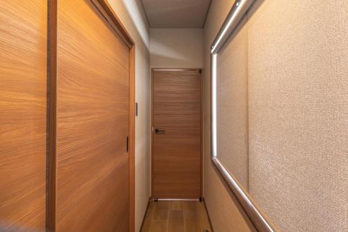 a hallway with a wooden door and a stairway at Kstyle Apartments UNO in Tamano
