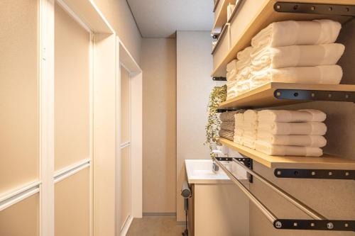 a bathroom with a towel rack with towels at Kstyle Apartments UNO in Tamano
