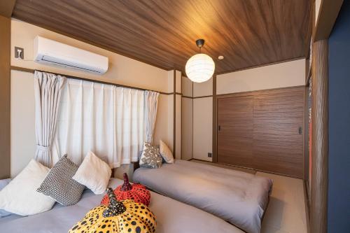 a bedroom with two beds and a window at Kstyle Apartments UNO in Tamano
