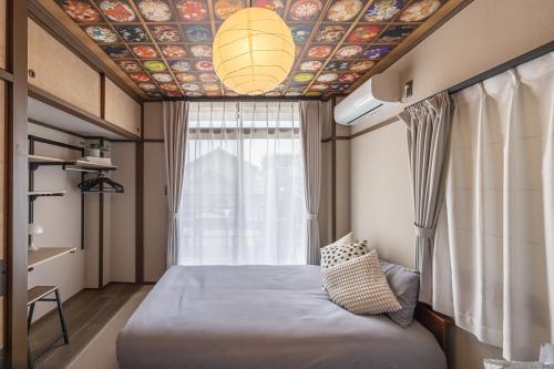 a bedroom with a bed and a ceiling with a mural at Kstyle Apartments UNO in Tamano