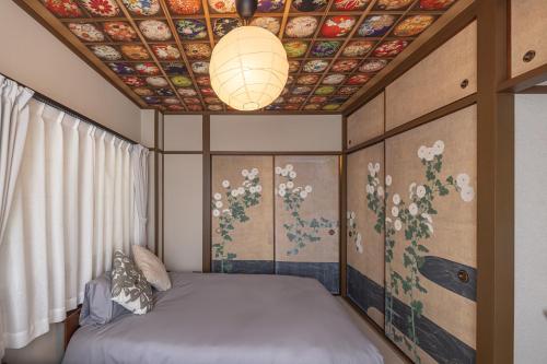 a room with a bed and a ceiling with flowers at Kstyle Apartments UNO in Tamano