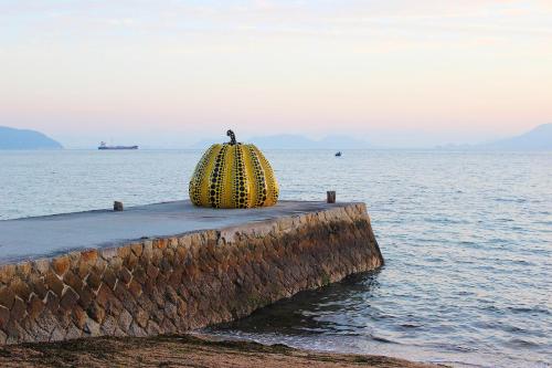 a yellow object sitting on a dock in the water at Kstyle Apartments UNO in Tamano