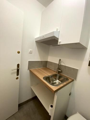 Il comprend une petite cuisine avec un lavabo et des toilettes. dans l'établissement Logement avec balcon, à Ouistreham