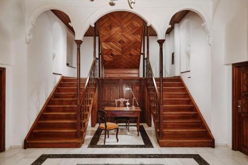 a hallway with wooden stairs and a wooden table and chair at Despotiko in Portariá