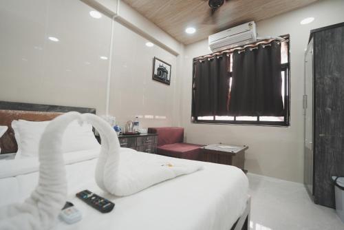 a hotel room with a bed with swans on it at Hotel Jupiter Residency in Mumbai