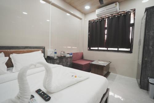 a bedroom with a white bed with a swan on it at Hotel Jupiter Residency in Mumbai