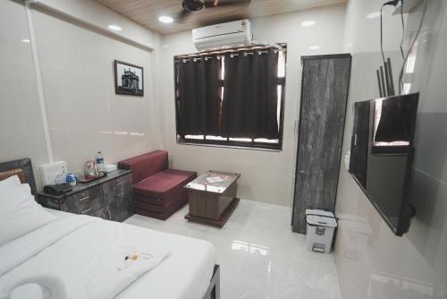 a bedroom with a bed and a sink and a window at Hotel Jupiter Residency in Mumbai