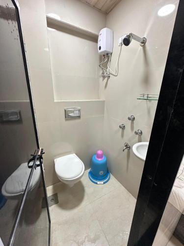 a bathroom with a toilet and a sink at Hotel Jupiter Residency in Mumbai