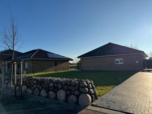 a stone retaining wall in front of a house at Ferienhaus RELAX in Büsum