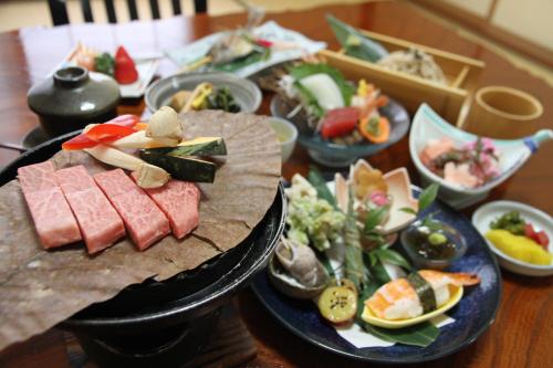 a wooden table with plates of food on it at ひらゆの森別邸湯う香三蔵庵 in Takayama