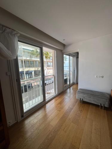 un salon vide avec un canapé et de grandes fenêtres dans l'établissement Reine Astrid Palm Beach, à Cannes