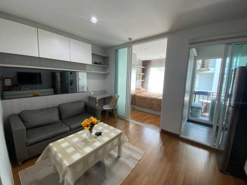 a living room with a couch and a table at Stunning Condo - BTS On Nut - Pool, Gym, Wi-Fi in Bangkok