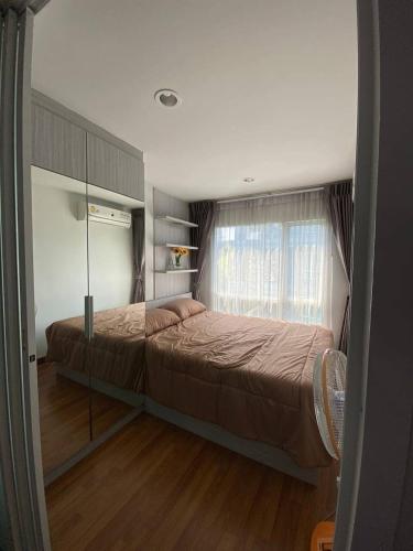 a bedroom with a large bed and a window at Stunning Condo - BTS On Nut - Pool, Gym, Wi-Fi in Bangkok