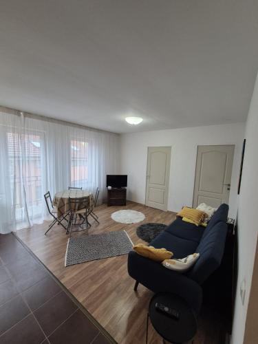 a living room with a blue couch and a table at COM Home Floresti in Floreşti