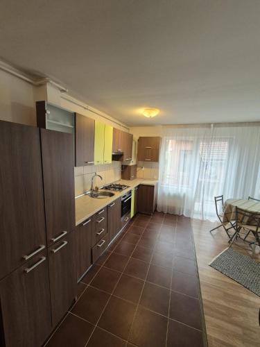 a kitchen with brown cabinets and a table in a room at COM Home Floresti in Floreşti