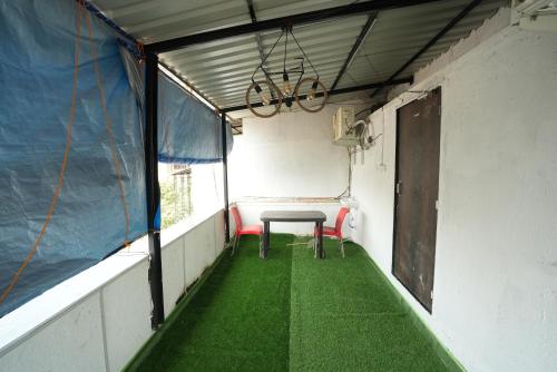 a small room with a table and a green floor at Hotel Jupiter Residency in Mumbai