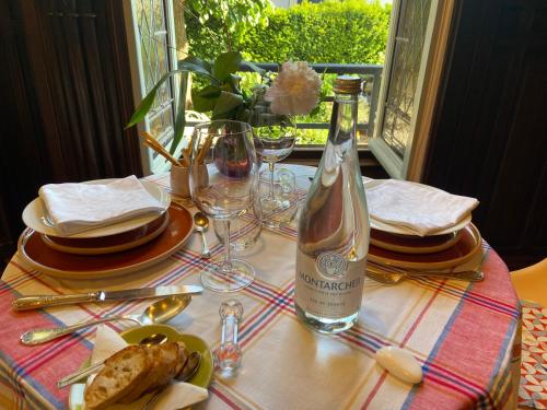 a bottle of wine sitting on a table with glasses at Le Passagran in Boën