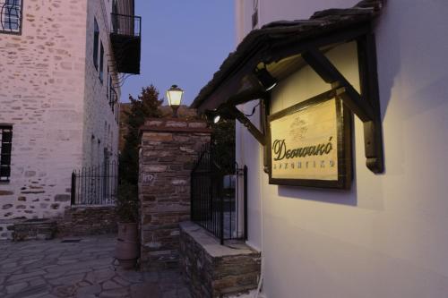 a sign for a restaurant on the side of a building at Despotiko in Portariá