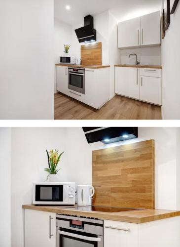 a kitchen with white cabinets and a microwave oven at Casa Caso in Achim