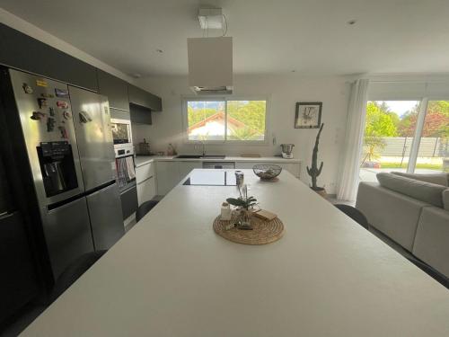 - une cuisine avec un comptoir blanc dans une pièce dans l'établissement Maison cosy au calme, à Tullins