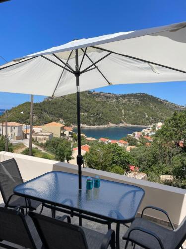 a table and chairs with an umbrella on a balcony at Asos Terrace House in Asos