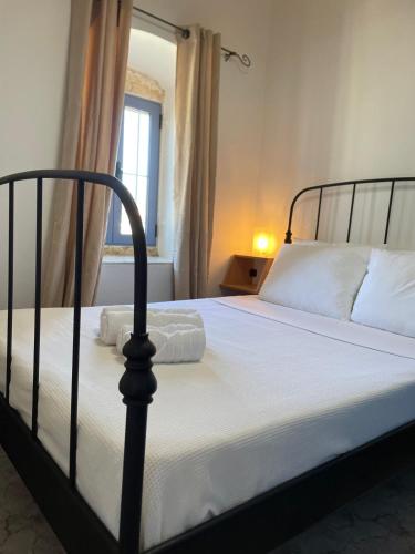 a bedroom with a bed with white sheets and a window at Asos Terrace House in Asos