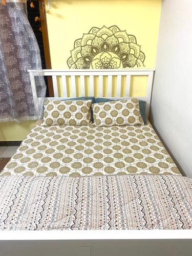 a bed in a room with a wall with a picture at Villa De Dunes 369, Orchid Home in Bengaluru