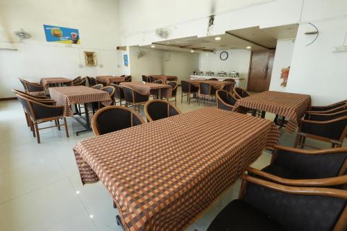 ein Esszimmer mit Tischen und Stühlen in einem Raum in der Unterkunft Hotel Aagam Executive in Aurangabad