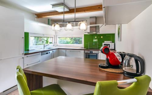 a kitchen with a wooden table and green chairs at Rodinné apartmány Rafael Bedřichov in Bedřichov
