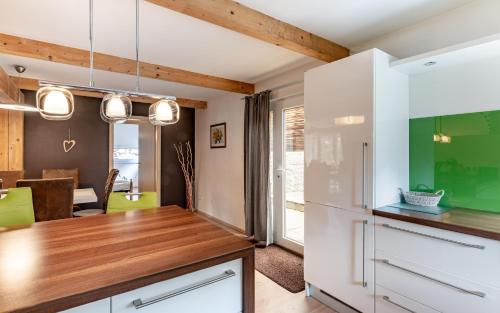a kitchen with white cabinets and a green wall at Rodinné apartmány Rafael Bedřichov in Bedřichov