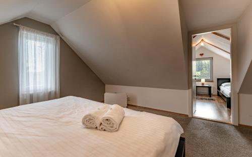 a bedroom with a bed with towels on it at Rodinné apartmány Rafael Bedřichov in Bedřichov