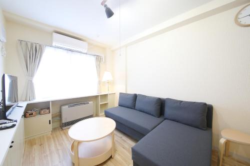 a living room with a blue couch and a table at ノーザンヒルズ南6条 in Sapporo