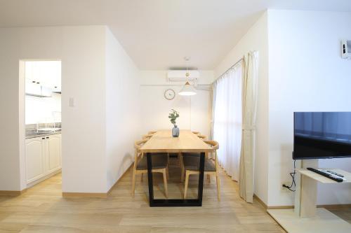 a dining room with a table and a television at ノーザンヒルズ南6条 in Sapporo